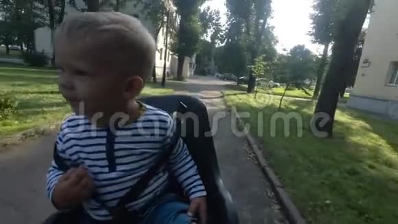 小男孩坐在自行车椅上一边开车一边环顾四周视频的预览图