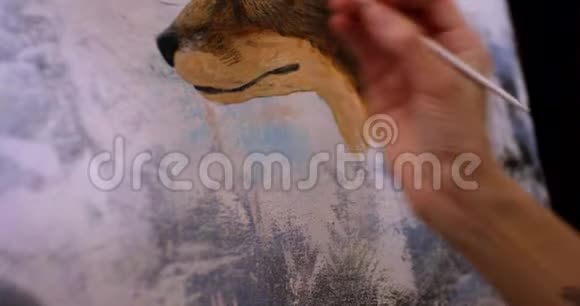 艺术家在她的车间里用丙烯酸颜料在画布上画画女孩艺术家画一幅画狐狸特写视频的预览图