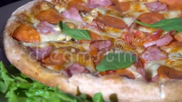 快关门带有西红柿和奶酪背景的披萨在厨房餐桌上旋转视频的预览图