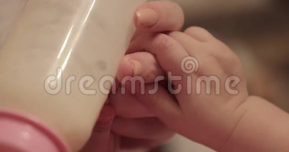 小孩子喝牛奶摸妈妈手特写视频的预览图