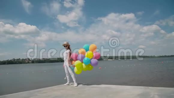 漂亮的女孩手拿着气球在沙发上表现出快乐的情绪视频的预览图
