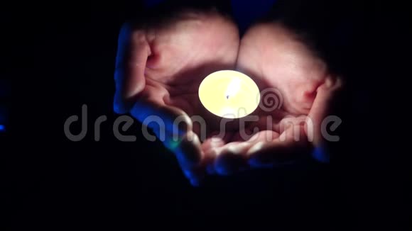 一支芳香的小蜡烛在一个黑色的人的手掌上特写4k慢镜头拍摄视频的预览图