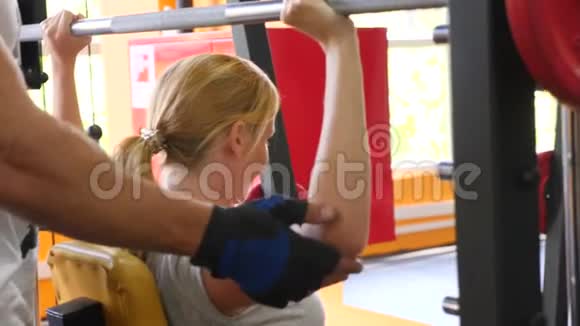 这名妇女与私人教练一起在健身房工作4k慢动作视频的预览图