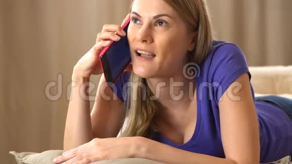 美丽迷人的年轻女子穿着紫罗兰色的t恤在打电话视频的预览图