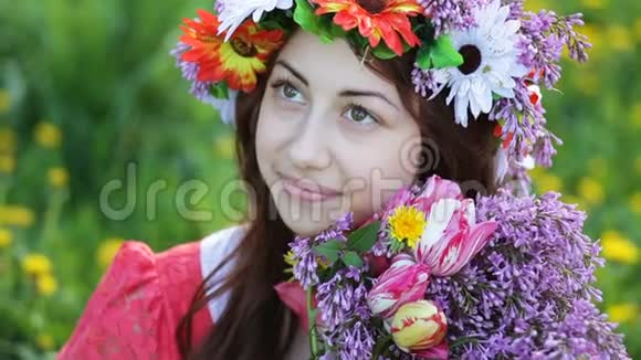 美丽的年轻女子头上戴着花环手里拿着一束紫丁香视频的预览图