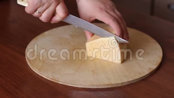 一个女人在剪盘上切奶酪特写视频的预览图