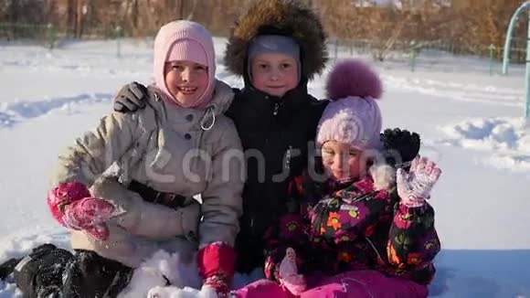快乐的孩子们拥抱在一起在冬天的公园里微笑视频的预览图