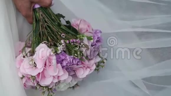新娘手捧花束与紫罗兰花视频的预览图