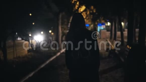 后景游客妇女背着背包走过黑暗公园附近的道路深夜独自视频的预览图
