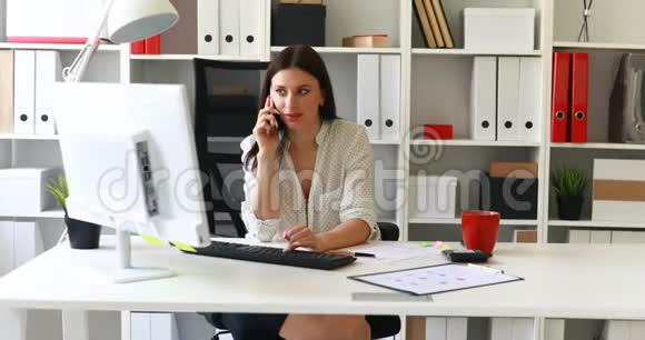 女商人坐在办公室椅子上打电话视频的预览图