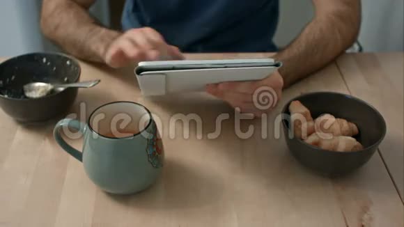 男人早餐桌上拿着数码平板电脑视频的预览图