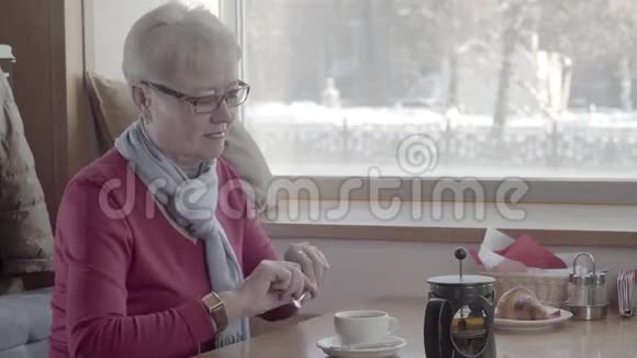 成熟的女人5060岁的咖啡馆搅动糖去喝茶视频的预览图