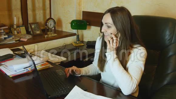 漂亮的商务女性在笔记本上工作在办公室打电话视频的预览图