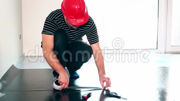 专业工人用胶带贴在地板下面视频的预览图