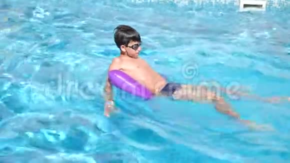 幼儿在水池里的充气枕头上游泳4k慢动作视频的预览图