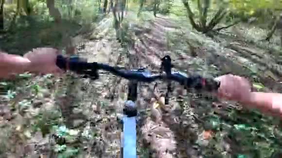 女孩骑自行车穿过森林女孩骑自行车沿着森林的小路视频的预览图