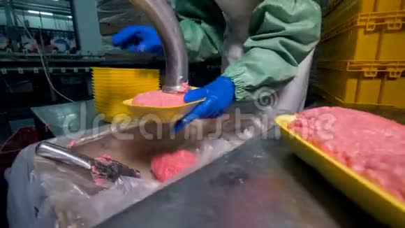 一个工人用许多塑料托盘包装地面肉视频的预览图