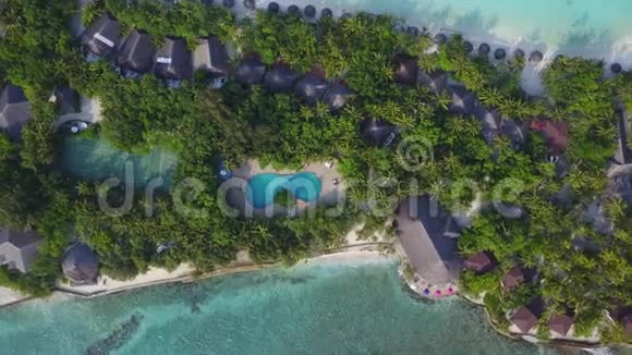 马尔代夫岛的俯视图相机正在下降到游泳池上的豪华酒店有很多度假胜地的空中录像视频的预览图