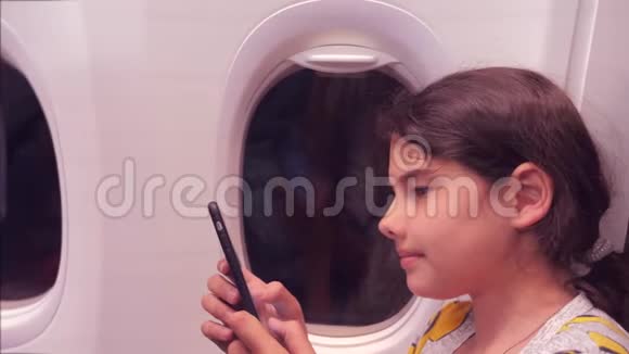 航空飞机概念小女孩正坐飞机在窗户旁边聊天的生活方式视频的预览图