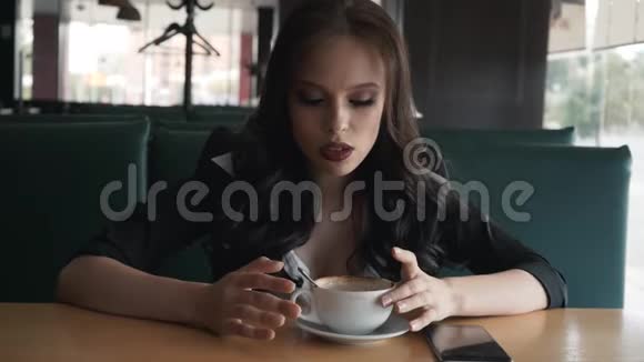 一个女孩坐在咖啡馆里穿着一套商务服这个女孩很漂亮讲个故事视频的预览图