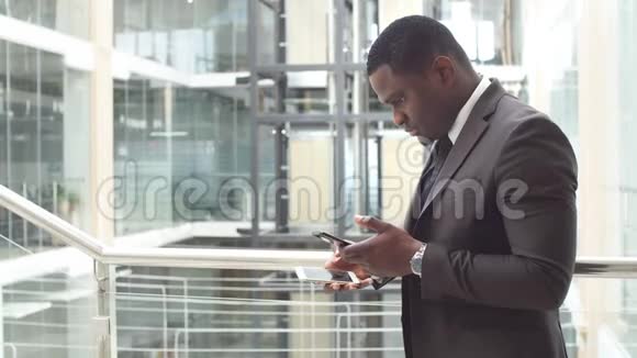 一个黑人用他的手机做生意一位非裔美国人的商业专家在他的手机上工作视频的预览图