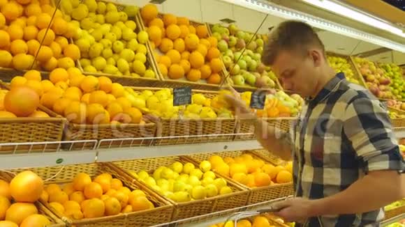 人在杂货店挑选新鲜水果然后把它放进塑料袋里年轻人选择视频的预览图
