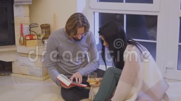 新婚夫妇在壁炉旁轻松阅读视频的预览图