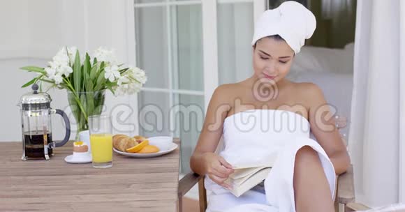 带着浴巾的女人在桌上看书视频的预览图