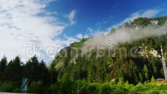奥地利美丽的风景从火车或汽车的窗户观看高山被森林和云层覆盖视频的预览图