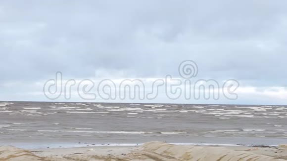 波涛汹涌的大海蓝天上有海鸥美丽的海景与鸟波浪白色泡沫微风飞溅沙子视频的预览图