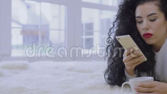 迷人的卷曲黑发短信与朋友视频的预览图