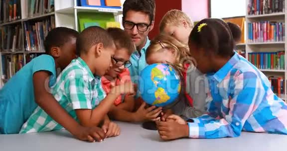孩子们和老师在图书馆看地球仪视频的预览图