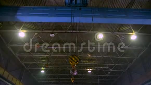 带有吊钩的重型桥式起重机在工厂旁边移动视频的预览图