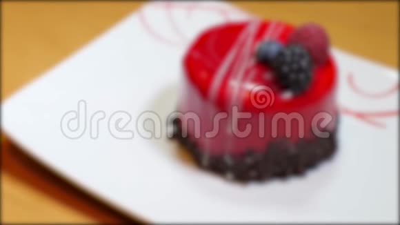 一个漂亮的红色单份蛋糕的照片放在一个白色的盘子里镜头聚焦并再次失去焦点视频的预览图