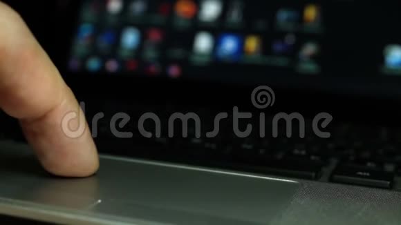 手指在笔记本电脑的触摸板上选择屏幕上的程序视频的预览图