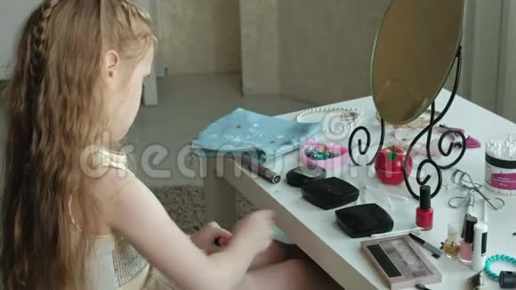 红发的小女孩在嘴唇上涂了口红照镜子化妆脸时尚时尚时尚化妆品视频的预览图