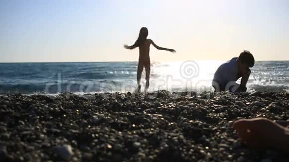 孩子和妈妈在海滩上休息而妈妈在日光浴视频的预览图