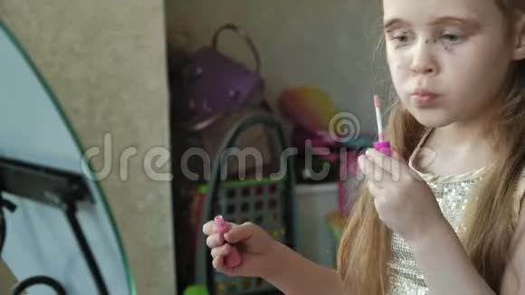 红发的小女孩在嘴唇上涂了口红照镜子化妆脸时尚时尚时尚化妆品视频的预览图