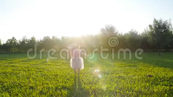 快乐的年轻女子在阳光明媚的秋日奔跑在草地上视频的预览图