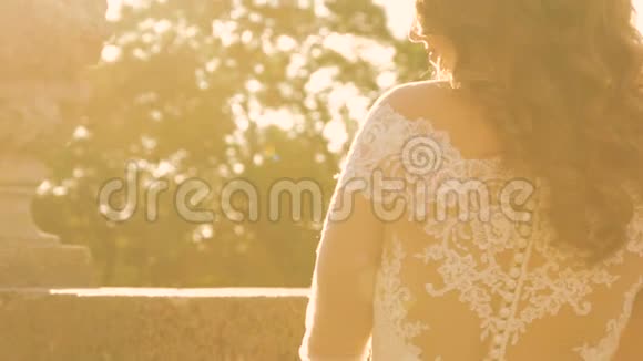温柔的新婚夫妇在户外的金色阳光下拥抱和抚摸视频的预览图