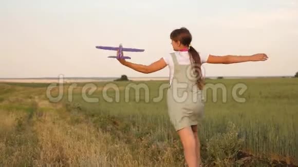 快乐女孩带着玩具飞机在花田上跑步孩子们玩玩具飞机少年梦想飞翔视频的预览图