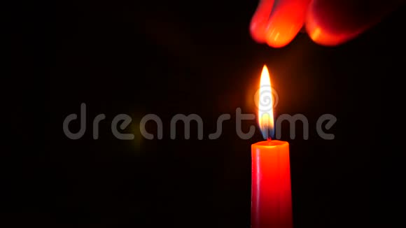 黑色蜡烛的特写有人用手指熄灭了红烛的火焰4k慢镜头拍摄视频的预览图