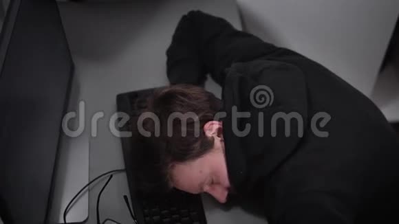 看一个穿着黑色夹克戴着兜帽的男人他睡着了一会儿只要工作但有一次他视频的预览图