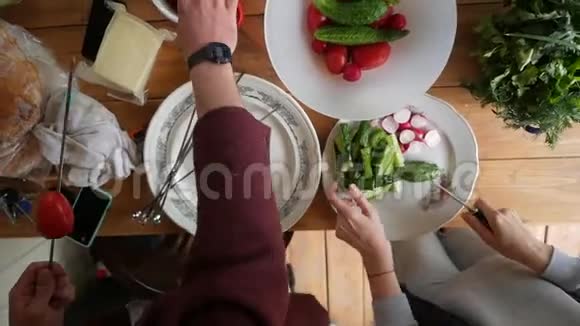 双手准备午餐蔬菜沙拉和烤菜从顶部看高清慢镜头视频的预览图
