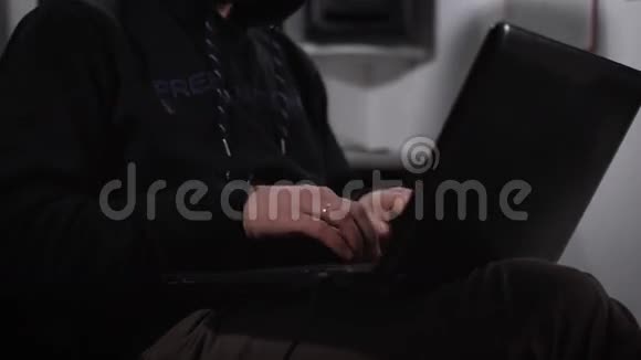 那个狡猾的人穿着一件黑色夹克头上戴着头罩在电脑显示器上打印文本视频的预览图