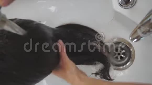 美发师手上的特写师父在一家黑色的美容院洗头发视频的预览图
