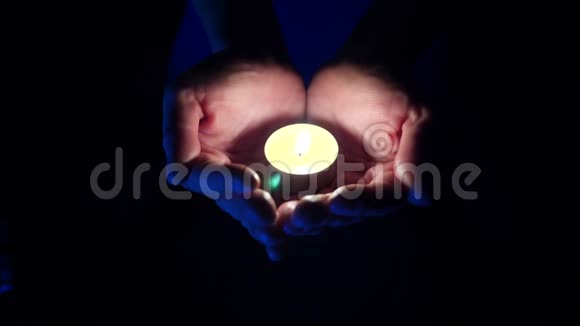 一支芳香的小蜡烛在一个黑色的人的手掌上特写4k慢镜头拍摄视频的预览图