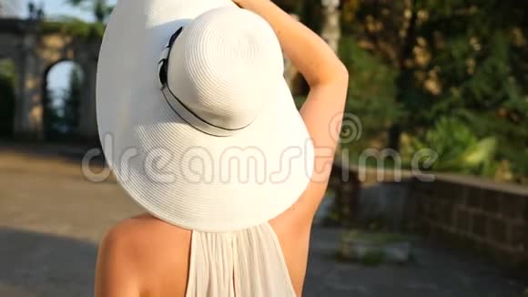 漂亮的女人脱下帽子在户外做发型动作缓慢快乐平静的长发女孩玩得开心视频的预览图
