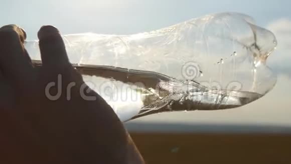 把大自然中的塑料瓶里的年轻人饮用水关起来日落时分有水的家伙男性简介视频的预览图