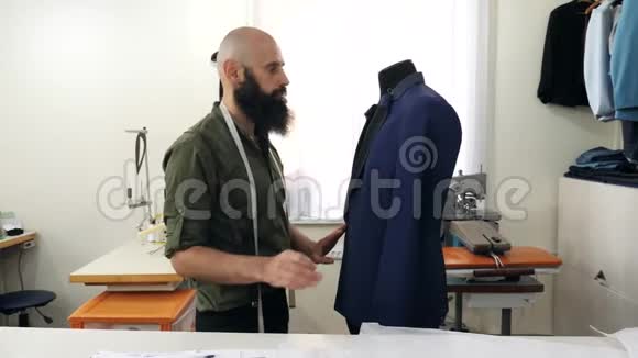裁缝把夹克的翻领放在假人身上视频的预览图
